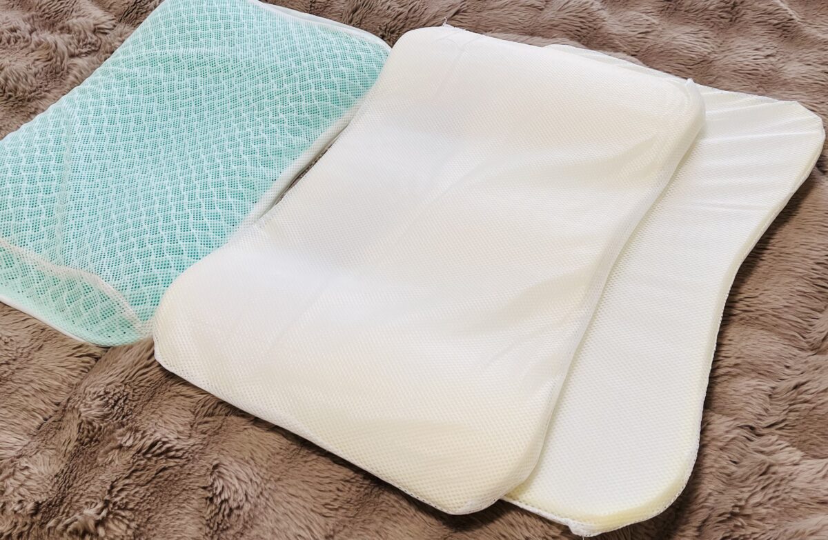 緑色のメッシュカバーと、取り出した白い中材2枚を毛布の上に並べたところ